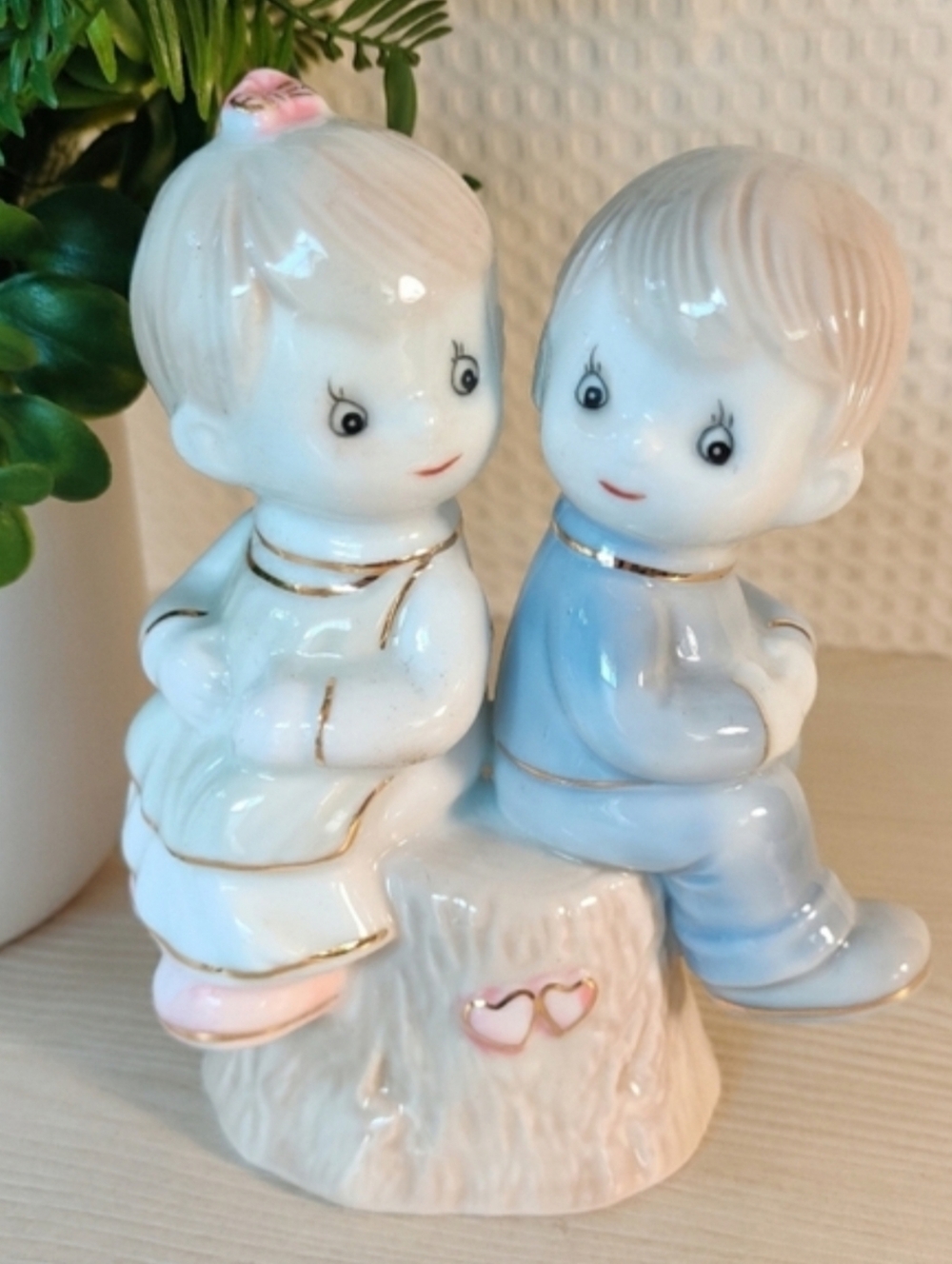 Ceramic figurine, girl and boy sitting on a tree stump